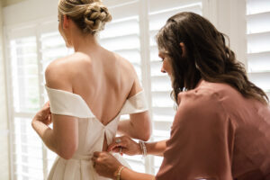 Bridesmaids Helping Bride Get Ready in Off the Shoulder Wedding Dress Portrait | Joyelan Photography