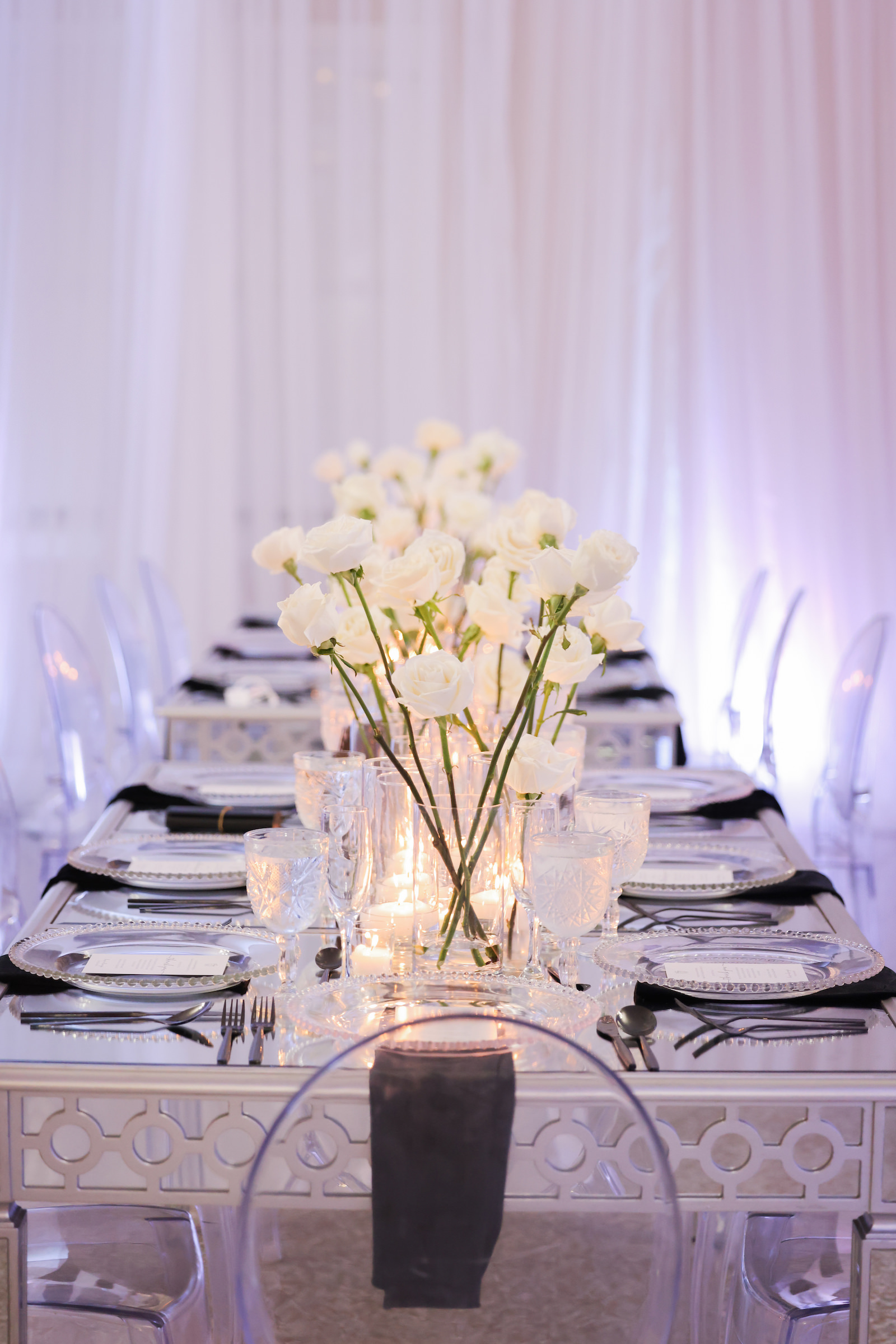 Modern Romantic Black and White Glam Wedding Reception Decor, Long Table, White Linen Draping, White Uplighting, Acrylic Ghost Chairs, Black Linen Napkins, White Single Roses Centerpieces, Floating Candles | Tampa Bay Wedding Photographer Lifelong Photography Studio | Wedding Rentals Gabro Event Services | Wedding Venue Davis Islands Garden Club