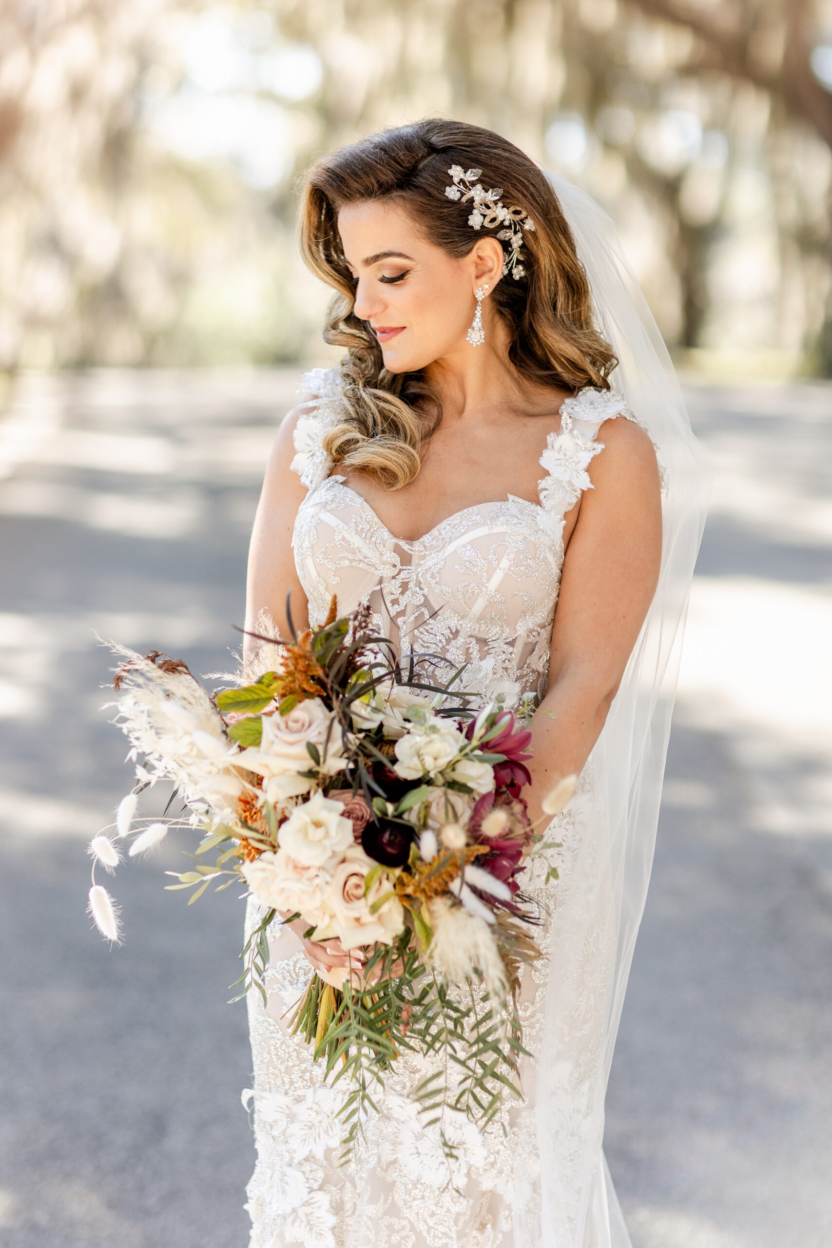Fall Boho Bride with Side Swept Hair in Crystal Hair Piece Beauty Portrait Holding Burnt Orange, Ivory Roses, Burgundy Flowers, Greenery, Pampas Grass and Dried Leaves Floral Bouquet | Tampa Bay Wedding Hair and Makeup Femme Akoi Beauty Studio