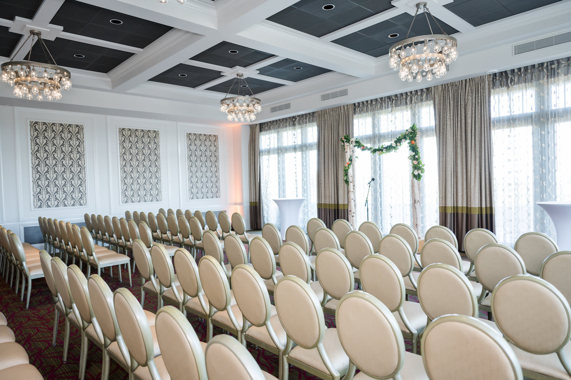 Indoor Wedding Ceremony with White Chairs and Greenery Arch | St. Pete Wedding Venue The Birchwood