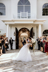 Winter Inspired Wedding, Groom Dip Kissing Bride Outside Traditional Wedding Ceremony Venue Harborside Chapel, Bubble Exit | Tampa Bay Wedding Planner MDP Events