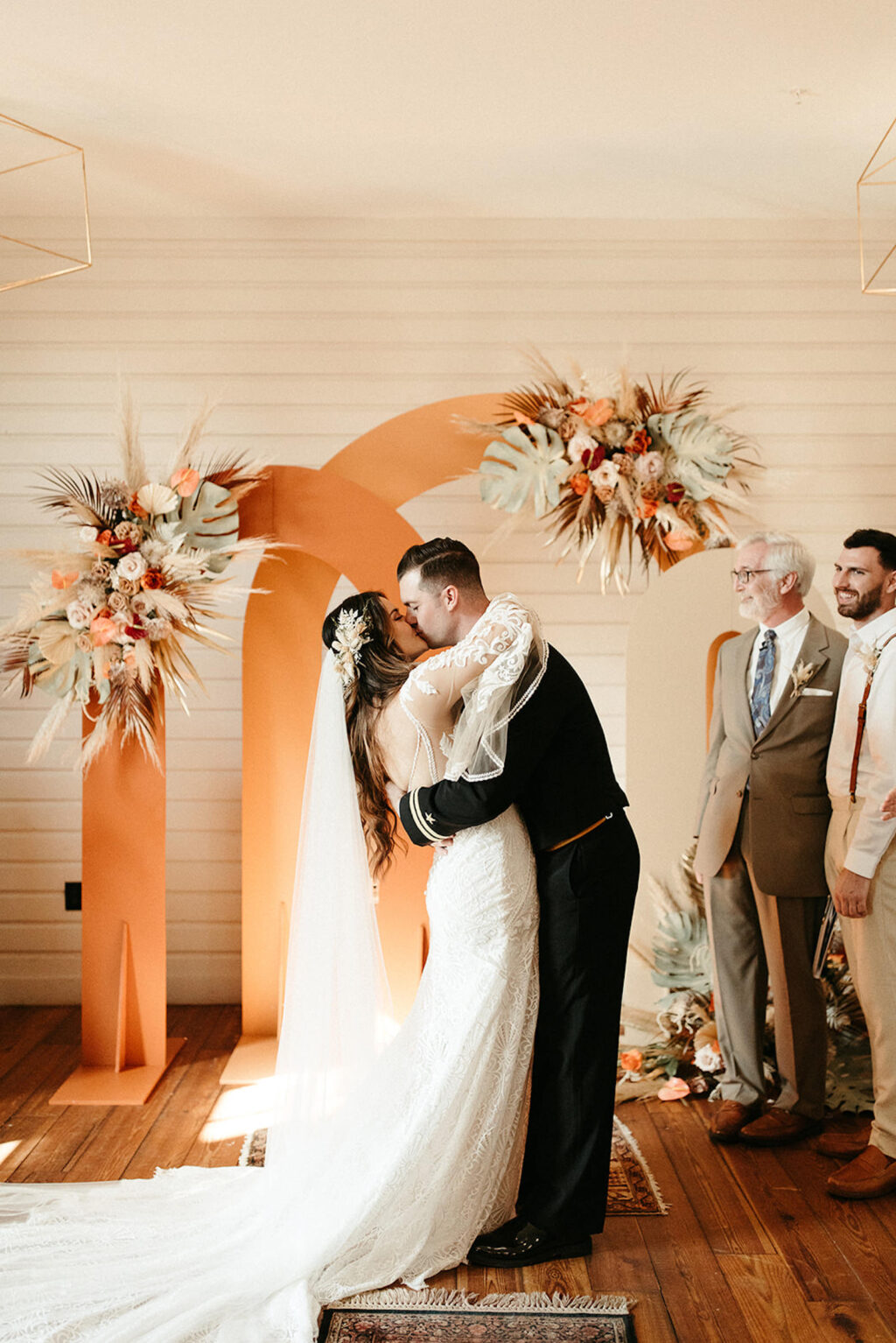 Earthy Neutral Boho Modern Chic Wedding, Emotional Bride and Groom Exchanging First Kiss, Arched Terracotta and Cream Panel Backdrops with Lush Floral Bouquets | Tampa Bay Wedding Planner Wilder Mind Events | Wedding Florist Save the Date Florida