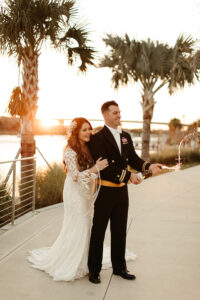 Earthy Neutral Boho Modern Chic Sunset Bride and Groom Wedding Portrait Popping Bottle of Champagne