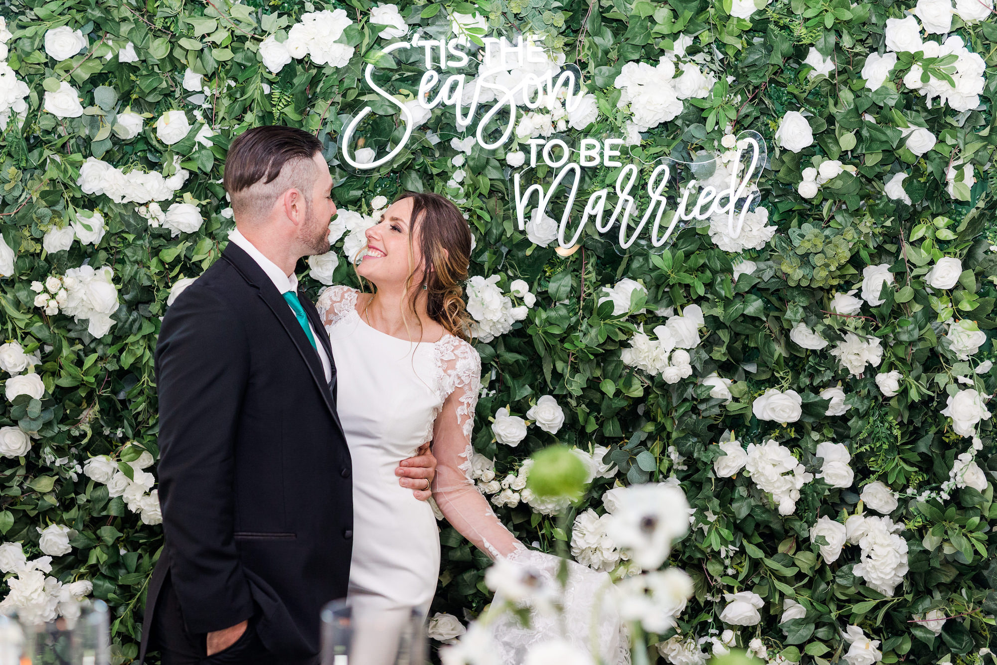 Winter Modern Whimsical Wedding Styled Shoot, Bride Wearing Long Sleeve Lace and Illusion Sleek Wedding Dress with Groom, Greenery and White Roses, Hydrangeas Lush Floral Wall Backdrop with White Neon Sign | Tampa Bay Wedding Planner MDP Events Planning | Wedding Dress Truly Forever Bridal Tampa
