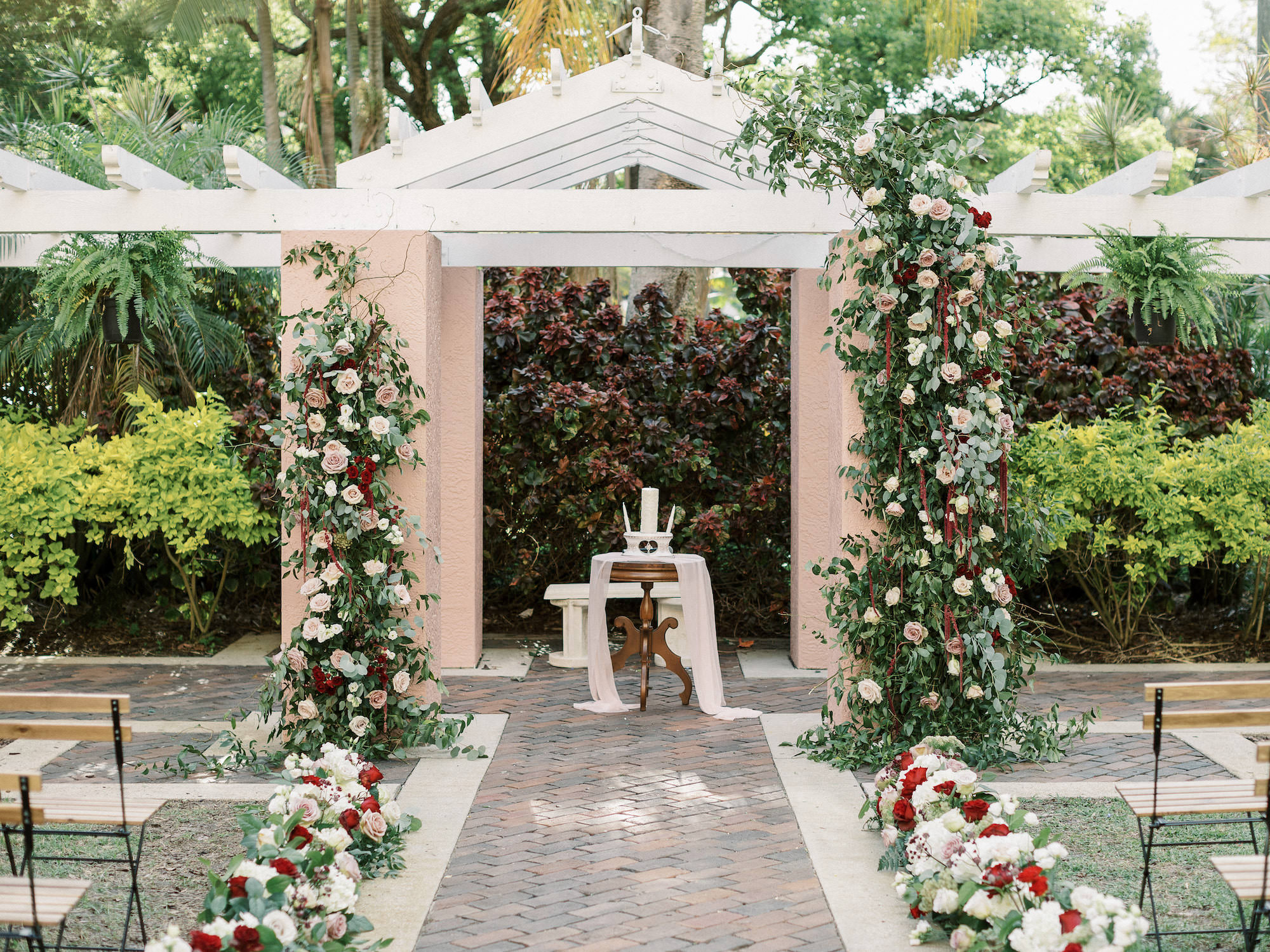 Royal Elegant Glam Gatsby Wedding Ceremony Decor, Outdoor Courtyard at St. Pete Wedding Venue The Vinoy Renaissance, Lush Greenery White, Red, Blush Pink and Mauve Roses Floral Pillars | Tampa Bay Wedding Planner and Designer John Campbell Weddings