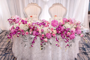 White Draping Reception Sweetheart Table with Bright Pink Floral Tablescape | Tampa Rentals A Chair Affair Event Rentals