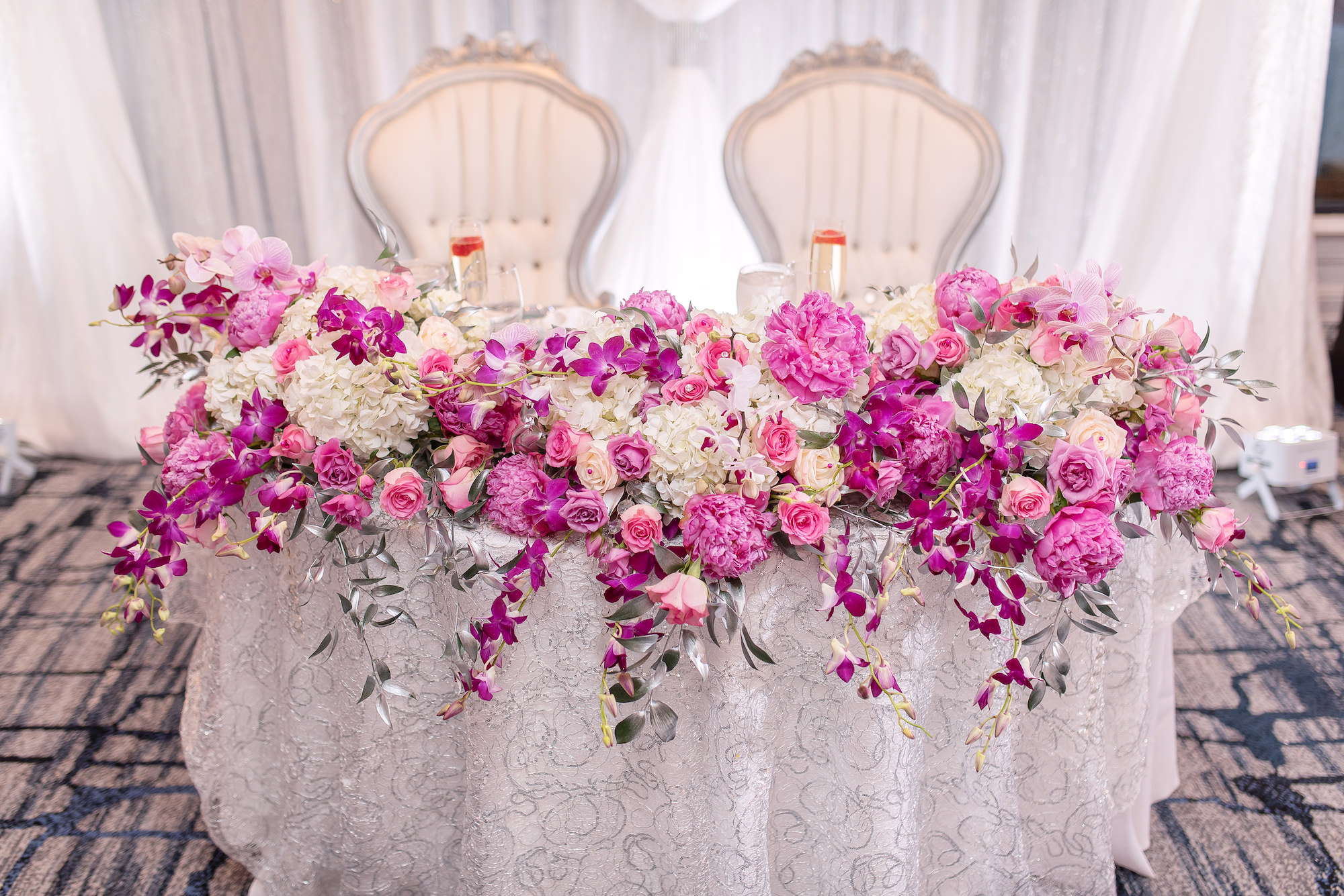 White Draping Reception Sweetheart Table with Bright Pink Floral Tablescape | Tampa Rentals A Chair Affair Event Rentals