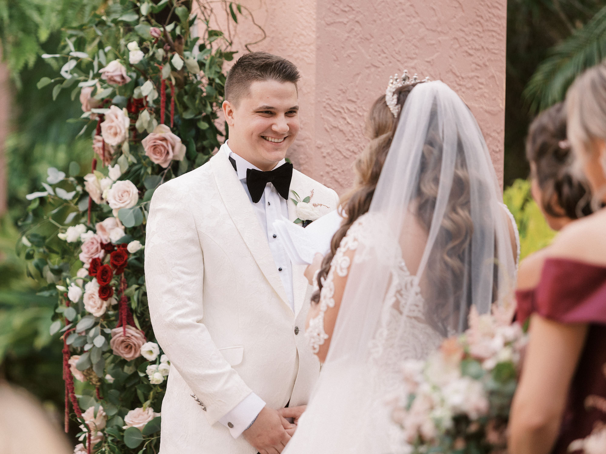 Emotionally Happy Groom Wearing White Tuxedo Jacket Looking at Bride During Wedding Ceremony Vow Exchange