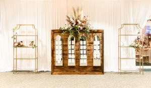 Fall Boho Elegant Wedding Ceremony Decor, Wooden Panel with Gold Mirrors Seating Cards with Lush Pampas Grass, Burnt Orange, Ivory Roses and Greenery Floral Bouquet, Tall Gold Shelves with Champagne Welcome Glasses | Tampa Bay Wedding Rentals Gabro Event Services