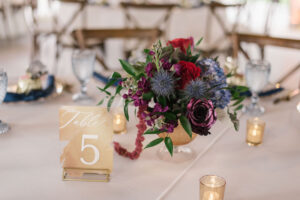 Purple, Indigo, and Hot Pink Floral Centerpieces with Gold Table Numbers with White Lettering