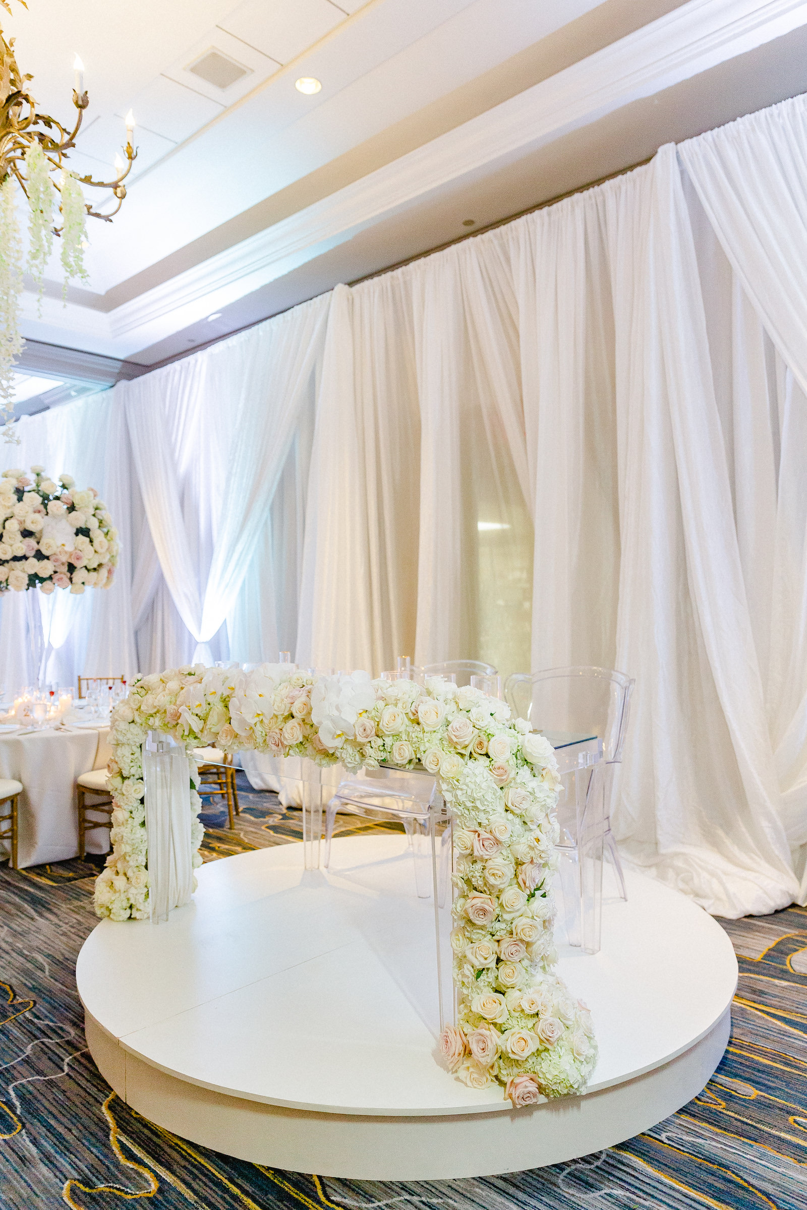 Romantic and Elegant All White Wedding Reception Decor, Acrylic Sweetheart Table and Chairs with Lush White and Blush Pink Roses, Hydrangeas Floral Waterfall Arrangement | Tampa Bay Wedding Florist Botanica International Design Studio