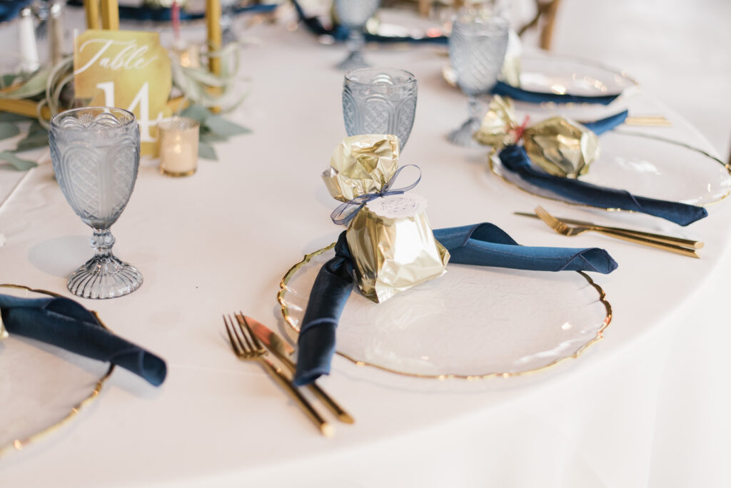 Clear Chargers with Gold Trim and Gold Flatware on White Linen | Kate Ryan Event Rentals
