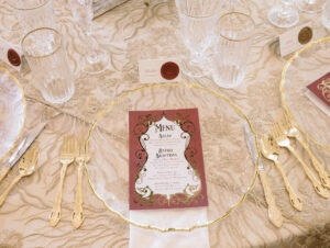 Elegant Royal Glam Gatsby Wedding Reception Decor, Gold Floral Applique Table Linen, Gold Scalloped Rim and Clear Glass Charger, Gold Flatware and Red with Gold Foil Menu | Tampa Bay Wedding Planner and Stationery John Campbell Weddings | St. Pete Wedding Rentals Kate Ryan Event Rentals