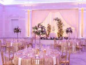 Elegant Royal Glam Gatsby Ballroom Wedding Reception Decor, Purple Uplighting, Round and Long Tables with Gold Chiavari Chairs, Tall Floral Centerpieces, Ivory and Gold Table Linens | St. Pete Wedding Venue The Vinoy Renaissance | Tampa Bay Wedding Rentals Kate Ryan Event Rentals | Wedding Planner and Designer John Campbell Weddings
