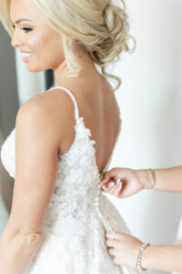 Modern Romantic Bride Getting Zipped Up in Floral Lace Applique Wedding Dress