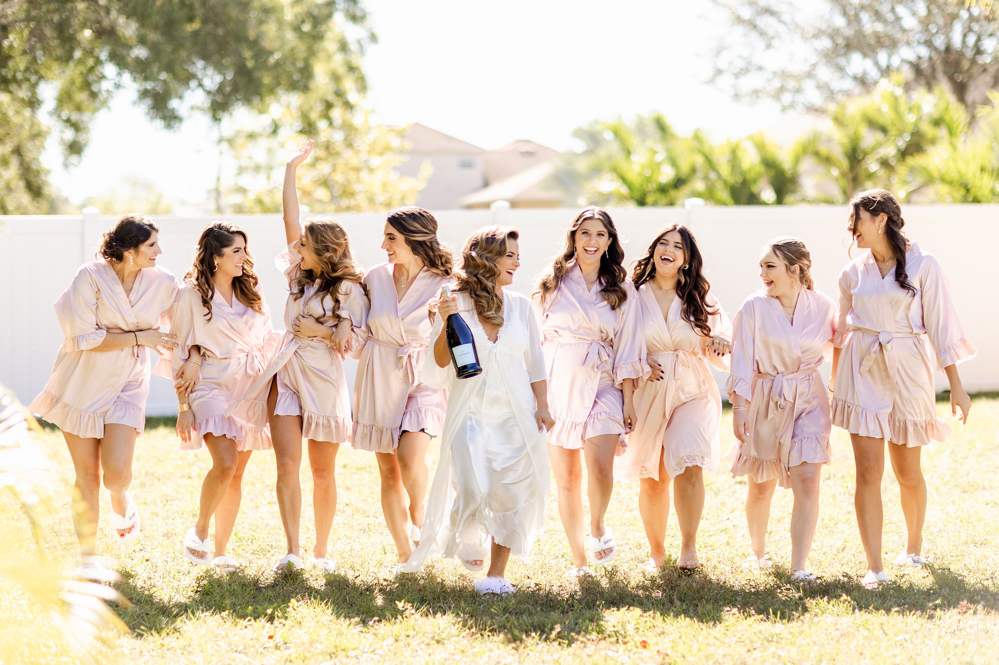 Fall Boho Bride and Bridesmaids with Bottle of Champagne and Matching Pink Robes | Tampa Bay Wedding Hair and Makeup Femme Akoi Beauty Studio