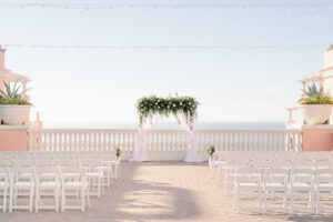 Rooftop Wedding Ceremony with White Arch and Greenery Detail with White Folding Chairs | Clearwater Wedding Rentals Kate Ryan Event Rentals | Florida Wedding Venue Hyatt Regency Clearwater Beach