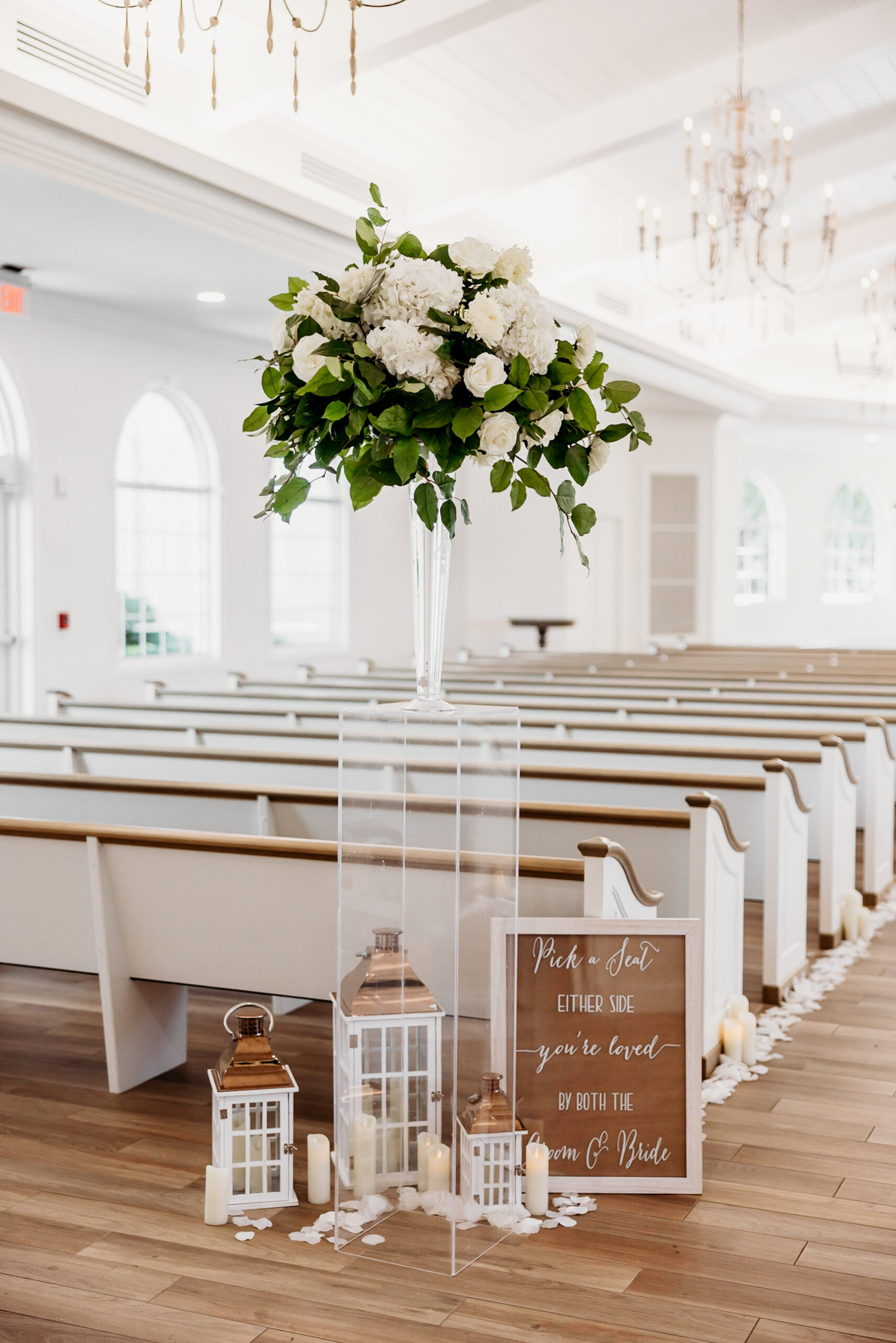 Winter Inspired Wedding Ceremony Decor, Acrylic Stand with Greenery and White Hydrangeas Floral Arrangement, White and Copper Lanterns, Wooden Pick a Seat Sign | Safety Harbor Traditional Wedding Ceremony Venue Harborside Chapel | St. Pete Wedding Planner MDP Events Planning