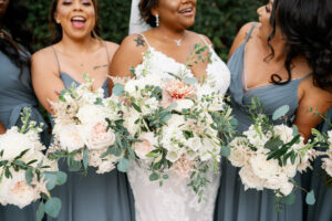 Same Sex Lesbian Wedding, Bride with Bridesmaids Wearing Mix and Match Gray Dresses Holding White and Greenery and Peach Floral Bouquets | Tampa Bay Wedding Photographer Dewitt for Love