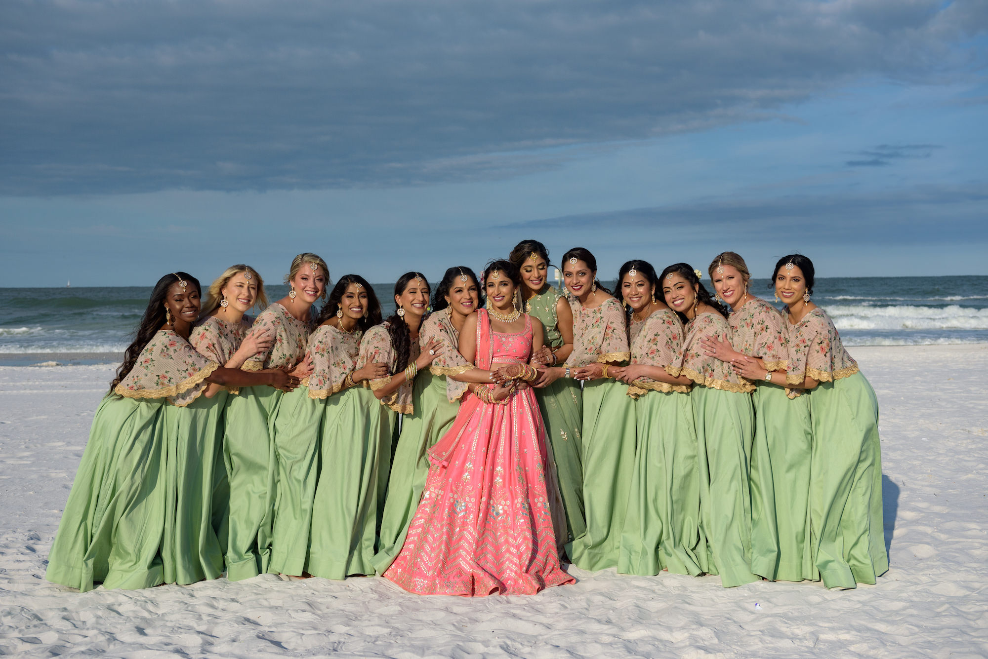 Bride and Bridesmaid on Clearwater Beach, Bride in Traditional Indian Wedding Dress a Pink Lehenga, Bridesmaids Wearing Green Sari Dress | Tampa Bay Wedding Hair and Makeup Artists Michele Renee the Studio
