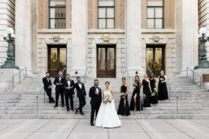 Classic Timeless Wedding Party, Bridesmaids Wearing Black Mix and Match Dresses Groomsmen in Black Tuxedos on Steps of Downtown Tampa Historic Wedding Venue Le Meridien | Tampa Bay Wedding Hair and Makeup Femme Akoi Beauty Studio | Wedding Florist Monarch Events and Design