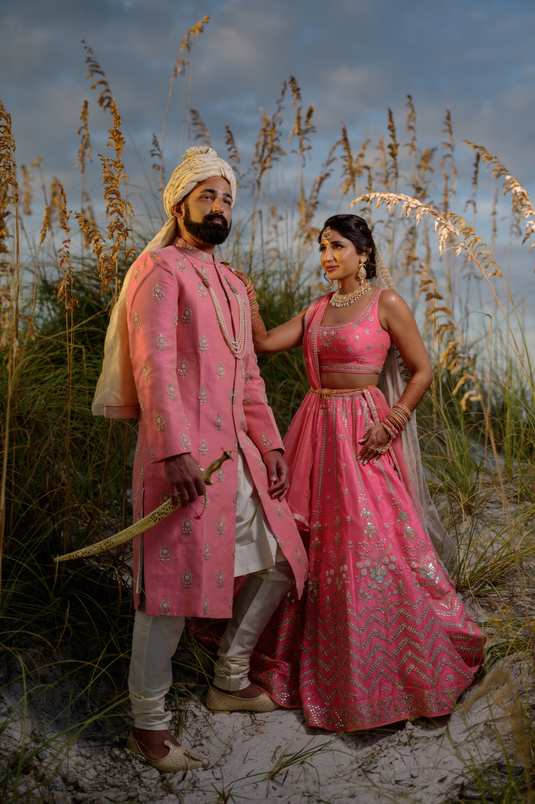 Florida Bride and Groom At Beach, Wearing Traditional Indian Wedding Attire in Bright Pink and Gold | Tampa Bay Hair and Makeup Artist Michele Renee The Studio | Venue Hilton Clearwater Beach Resort