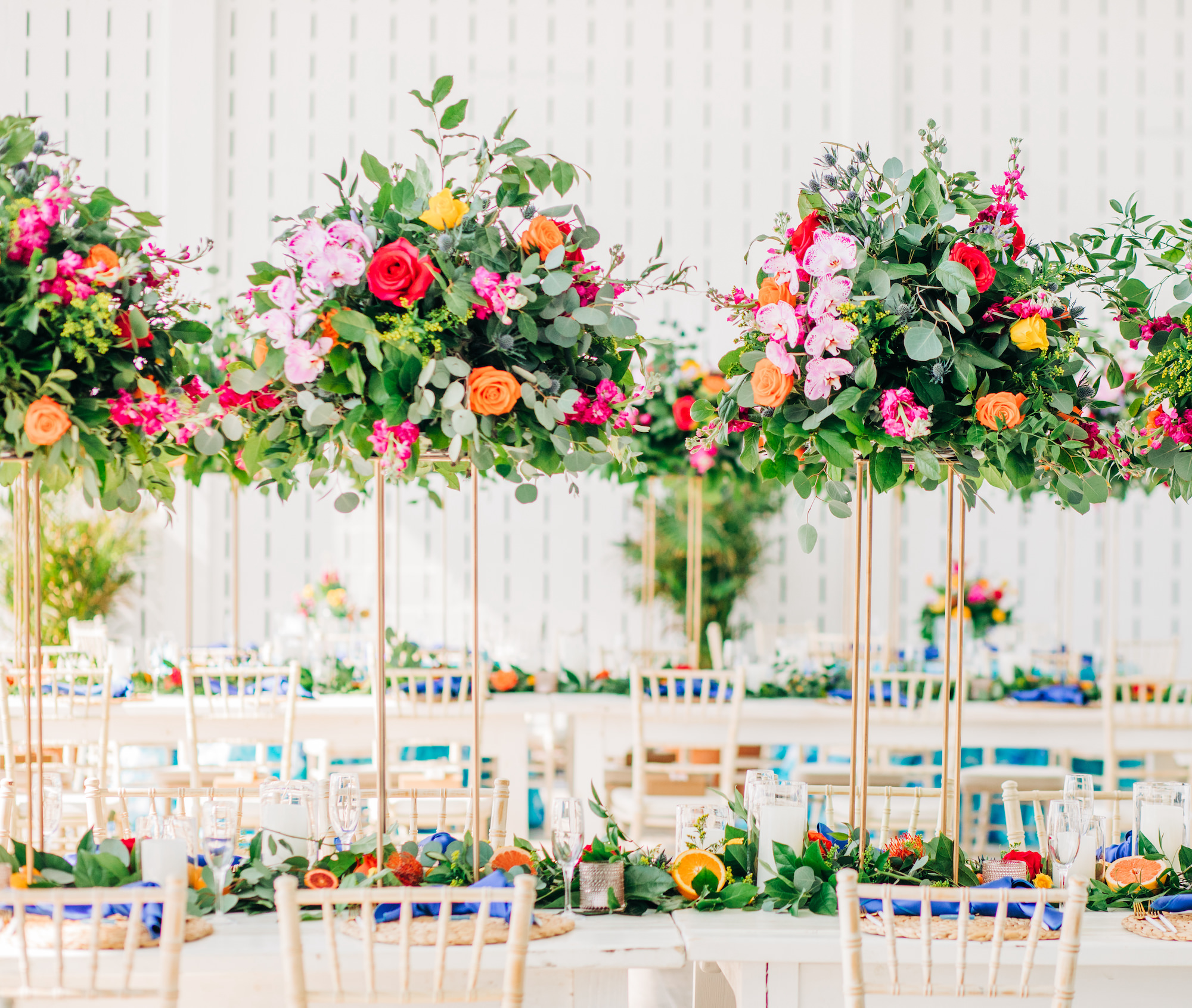 Vibrant Colorful Wedding Reception Decor, Long Tables with Tall Gold Stands and Lush Greenery, Red and Orange Roses, Pink Orchids, Eucalyptus, Floral Centerpieces | Tampa Bay Wedding Rentals A Chair Affair | Kate Ryan Event Rentals