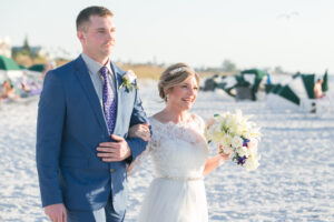 Classic Bride Wearing Half Sleeve Lace Bodice and Tulle Skirt Wedding Dress with Yellow Gold and Crystal Belt Holding White and Blush Pink Roses Floral Bouquet Walking with Son During Wedding Ceremony Aisle | Tampa Bay Wedding Photographer Carrie Wildes Photography | Wedding Hair and Makeup Adore Bridal