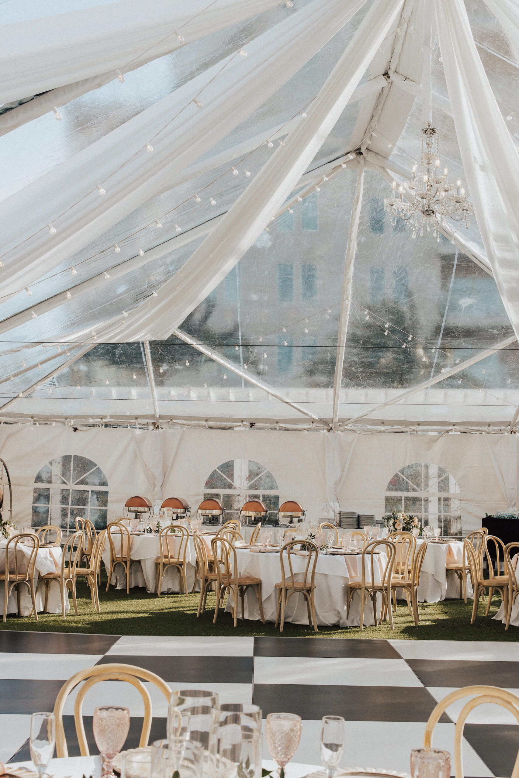 Elegant Garden Clear Tent Wedding Reception with Market Lights, White Drapery, Chandeliers, and Black and White Dance Floor | Outdoor Reception Ideals