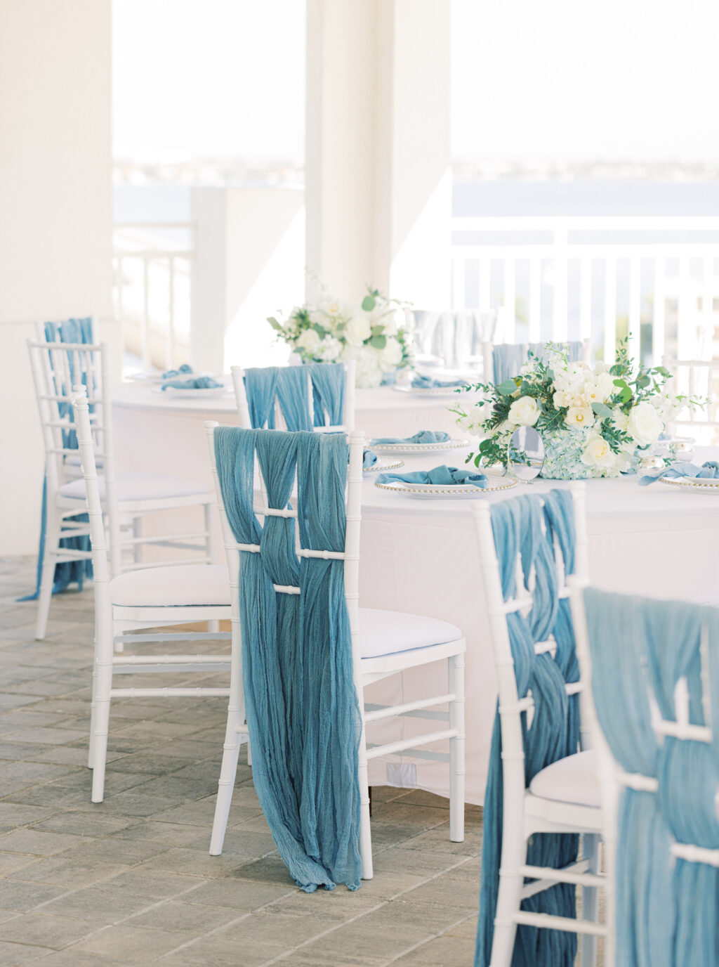 White Chairs with Blue Linen Back Detailing | Tampa Rentals Gabro Event Services