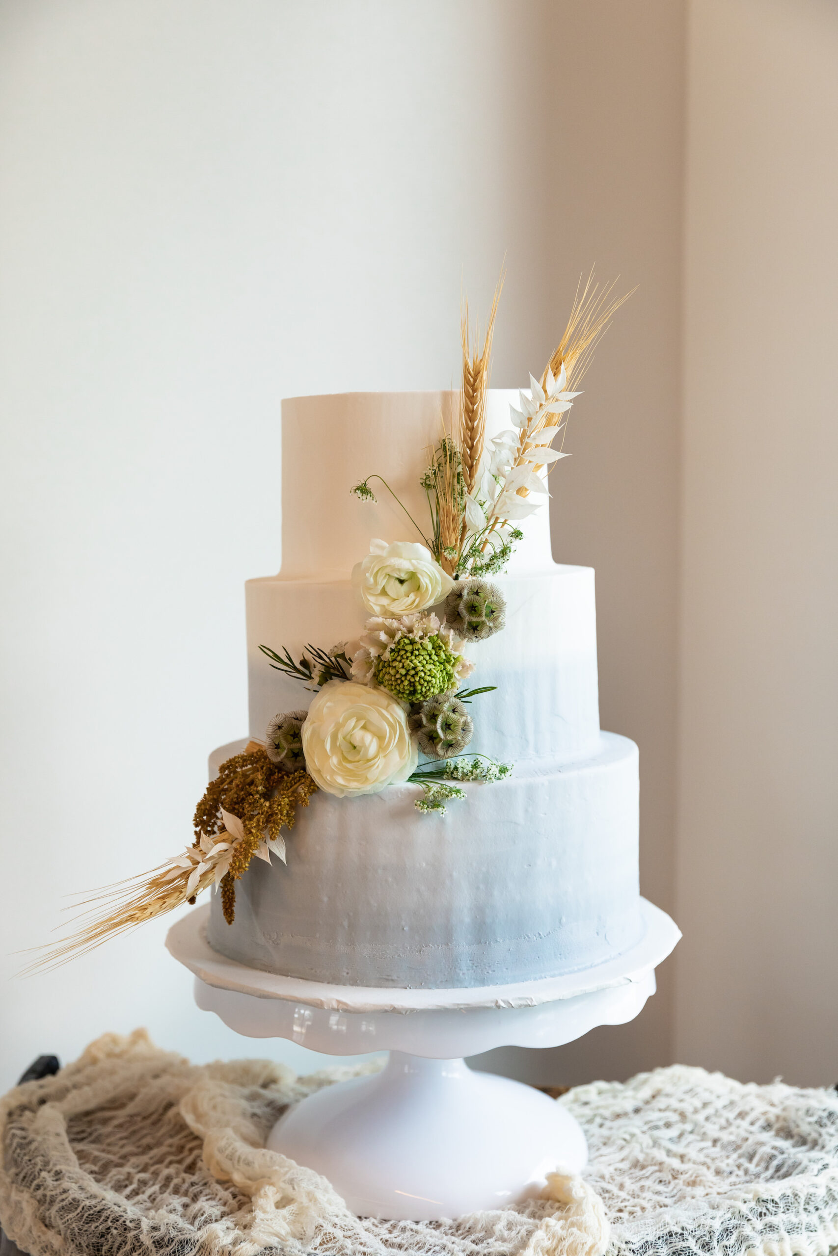 Three Tier White and Light Blue Ombre Wedding Cake with Dried Flowers Floral PIece