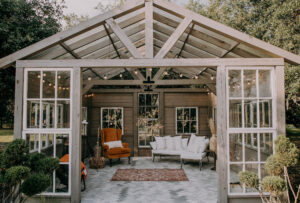 Outdoor Wooden and Glass Garden House with Lounge Seating, Terracotta Arm Chair, String Lights | Tampa Bay Wedding Planner Stephany Perry Events | Wedding Venue Mill Pond Estate