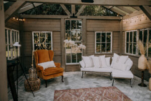 Outdoor Wooden and Glass Garden House with Lounge Seating, Terracotta Arm Chair, String Lights | Tampa Bay Wedding Planner Stephany Perry Events | Wedding Venue Mill Pond Estate