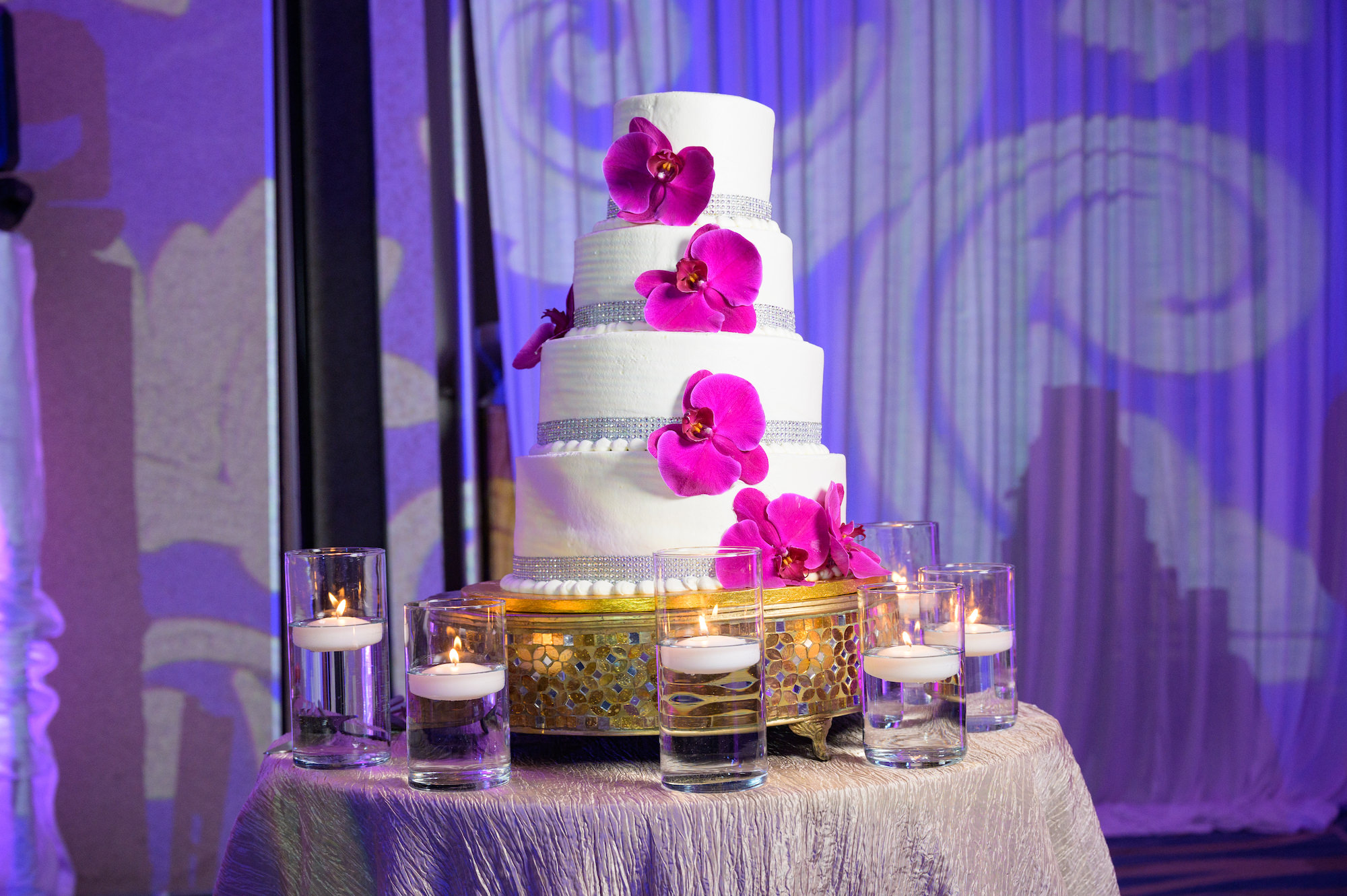 Tropical Round Four Tier Wedding Cake, White Buttercream Icing with Fuchsia Orchids Crystal Embellishments, Gold Decorative Cake Stand