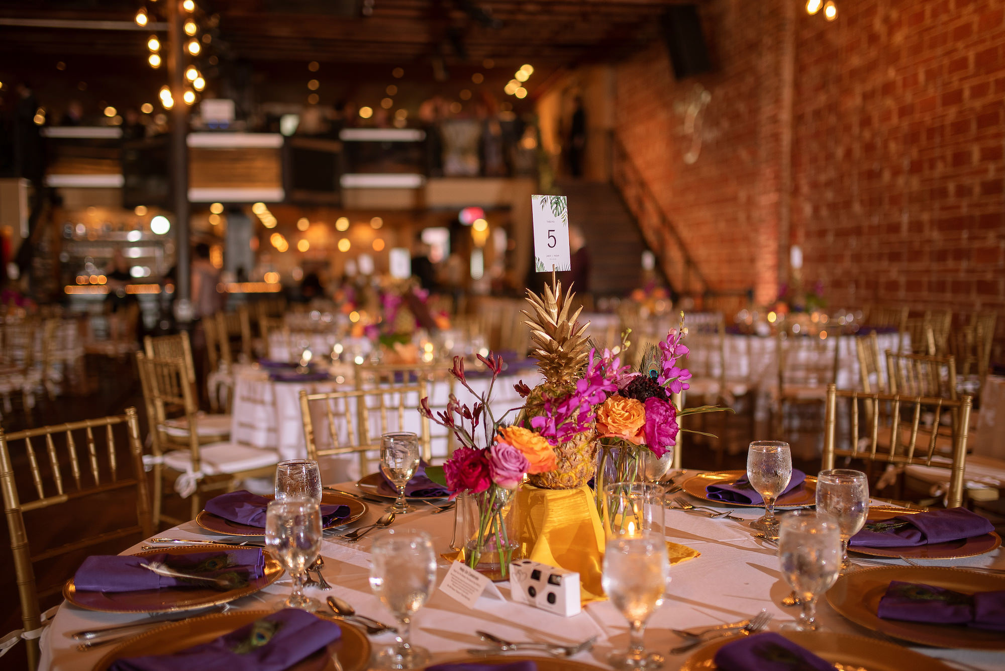 Industrial Indoor Wedding Reception White Linens and Gold Chairs with Tropical Inspired Details and Centerpieces | St. Pete Wedding Venue Nova 535