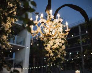 Dramatic Outdoor Chandelier and Hanging White Rose Flower Arrangement Beach Wedding Reception Inspiration | Sarasota Lighting and Rental Company Gabro Event Services