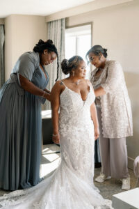 Bride Wearing Lace Deep V Neckline and Spaghetti Straps Wedding Dress with Mother and Bridesmaid Getting Wedding Ready | Tampa Bay Wedding Photographer Dewitt for Love | Wedding Hair and Makeup Imago Dei by Milan
