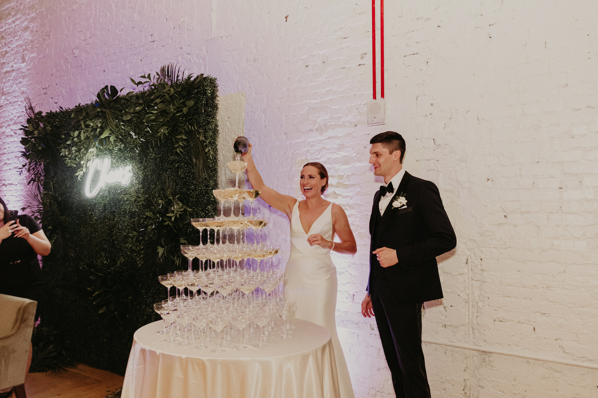 Bride Pouring Champagne Tower at Wedding Reception