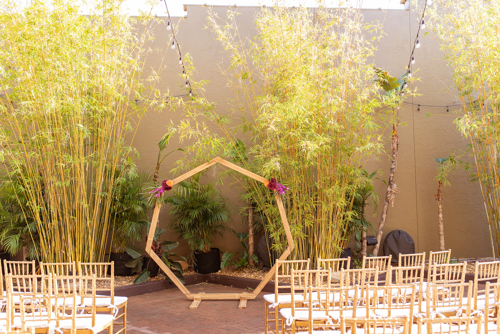 Gold Octagon Arch with Fuchsia Detailing in Tropical Outdoor Wedding and Gold Chiavari Chairs | St. Petersburg Wedding Venue Nova 535