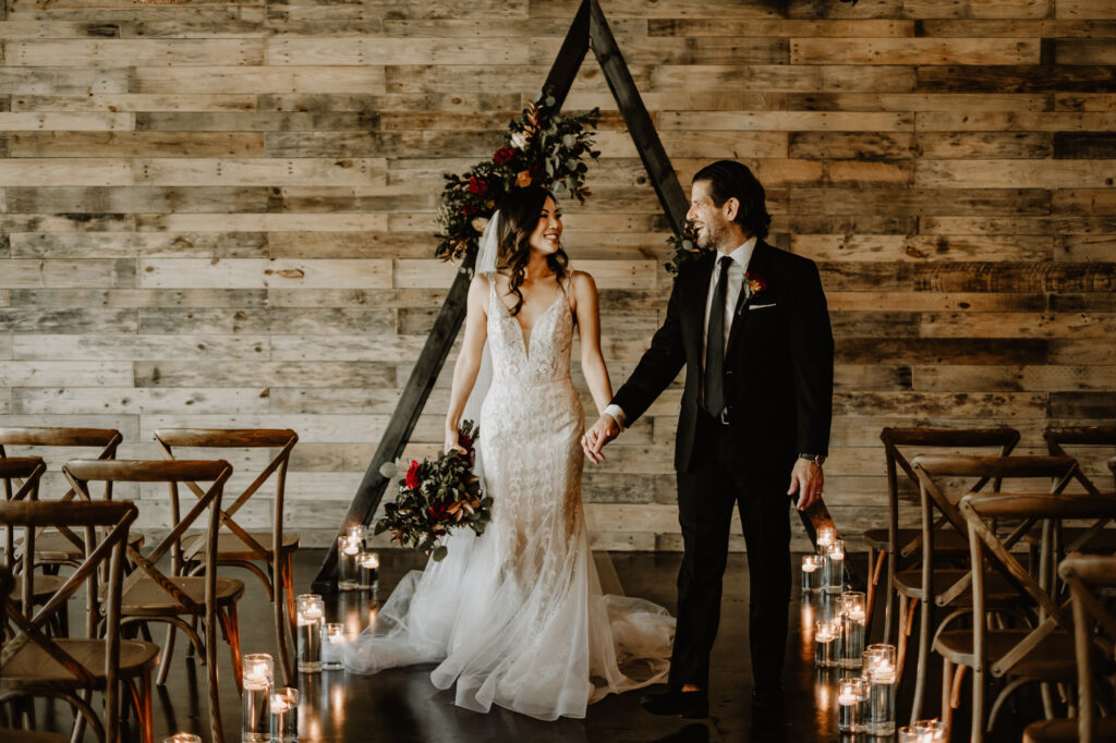 Nude and Ivory Lace Fit and Flare Wedding Dress with Plunging V-Neckline | Indoor Wood Pallet Wall Ceremony | Tampa Bay Wedding Attire Truly Forever Bridal | Tampa Bay Wedding Venue The West Events