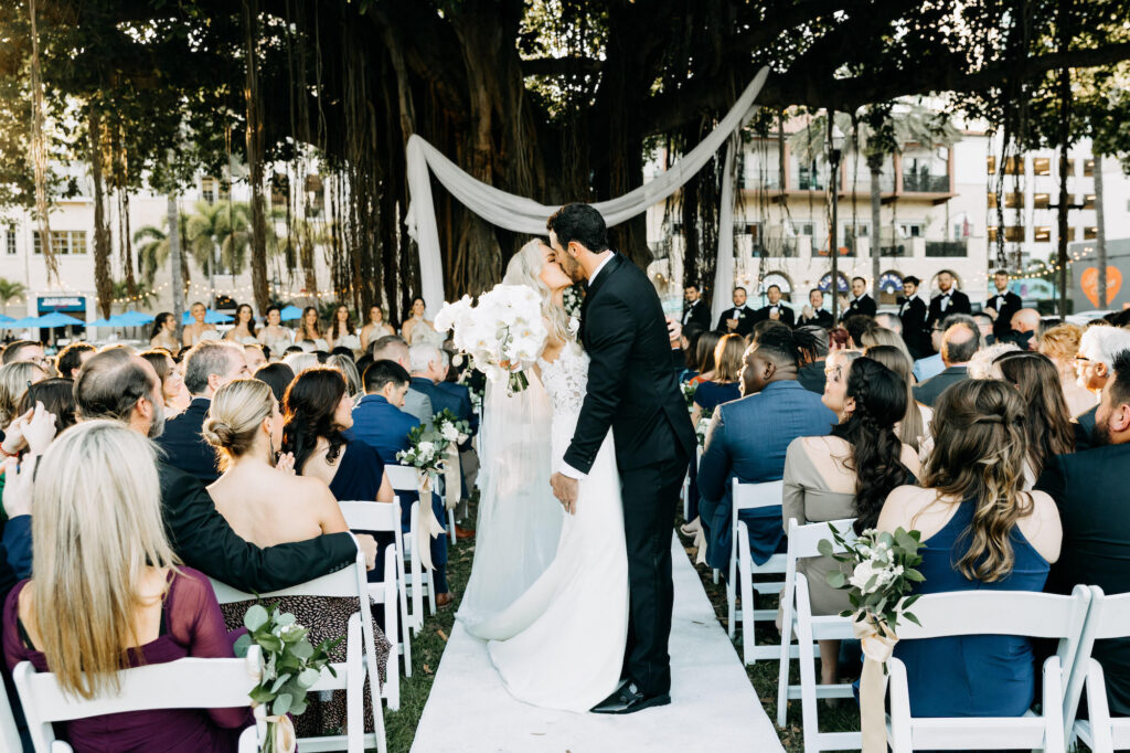 Bride and Groom Kiss at End of Ceremony Aisle Wedding Portrait | Tampa Bay Wedding Planner Wilder Mind Events | Tampa Bay Videographer J&S Media | Downtown St. Pete Venue N. Straub Park