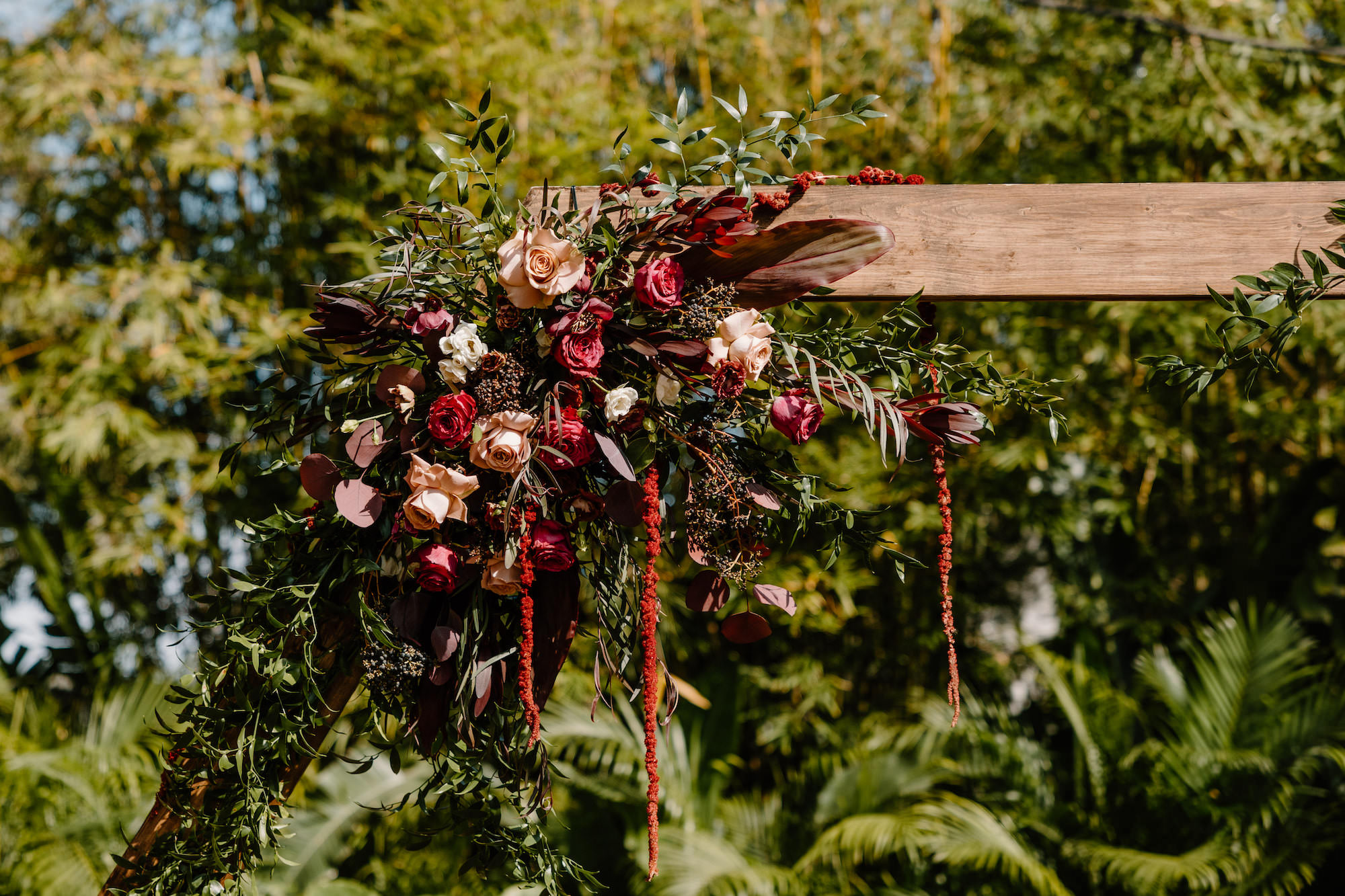 Dark and Moody Gothic Wedding Ceremony Arch with Red, Maroon, Blush and White Floral Arrangements with Greenery