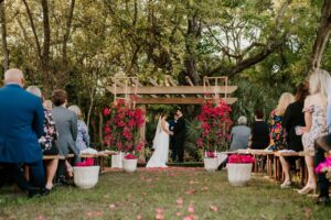 Outdoor Nature Inspired Ceremony Site Wood Benches Pergola Bold Pink Bouganvillea Flowers | Tampa Bay Wedding Venue Tabellas at Delaney Creek