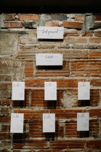 Classic Simple Black and White Wedding Reception Decor, Brick Wall with Hanging Cardstock Seating Chart | Tampa Bay Wedding Photographer Amber McWhorter Photography