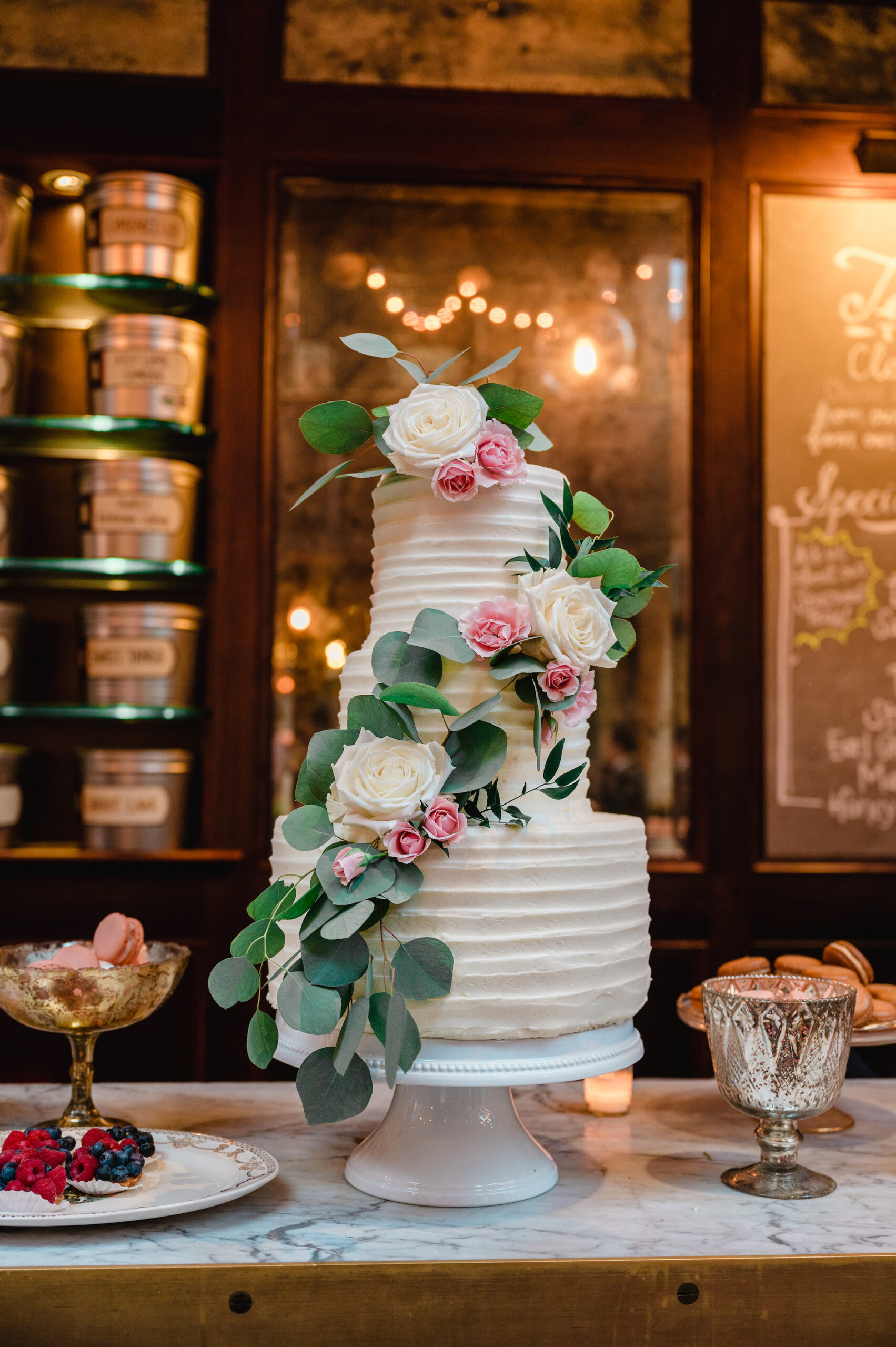 Three-Tiered Round Textured Buttercream Wedding Cake with Cascading Blush Pink Flowers and Greenery
