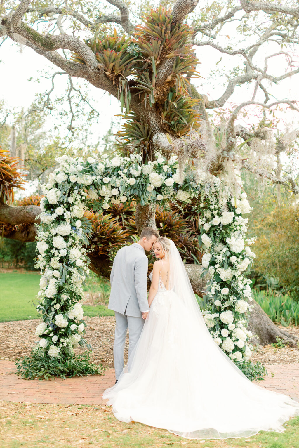 White and Greenery Spring Garden Floral Ceremony Arch | Romantic Bride and Groom Wedding Portrait | Sarasota Wedding Planner MDP Events | Florist Botanica International Design Studio