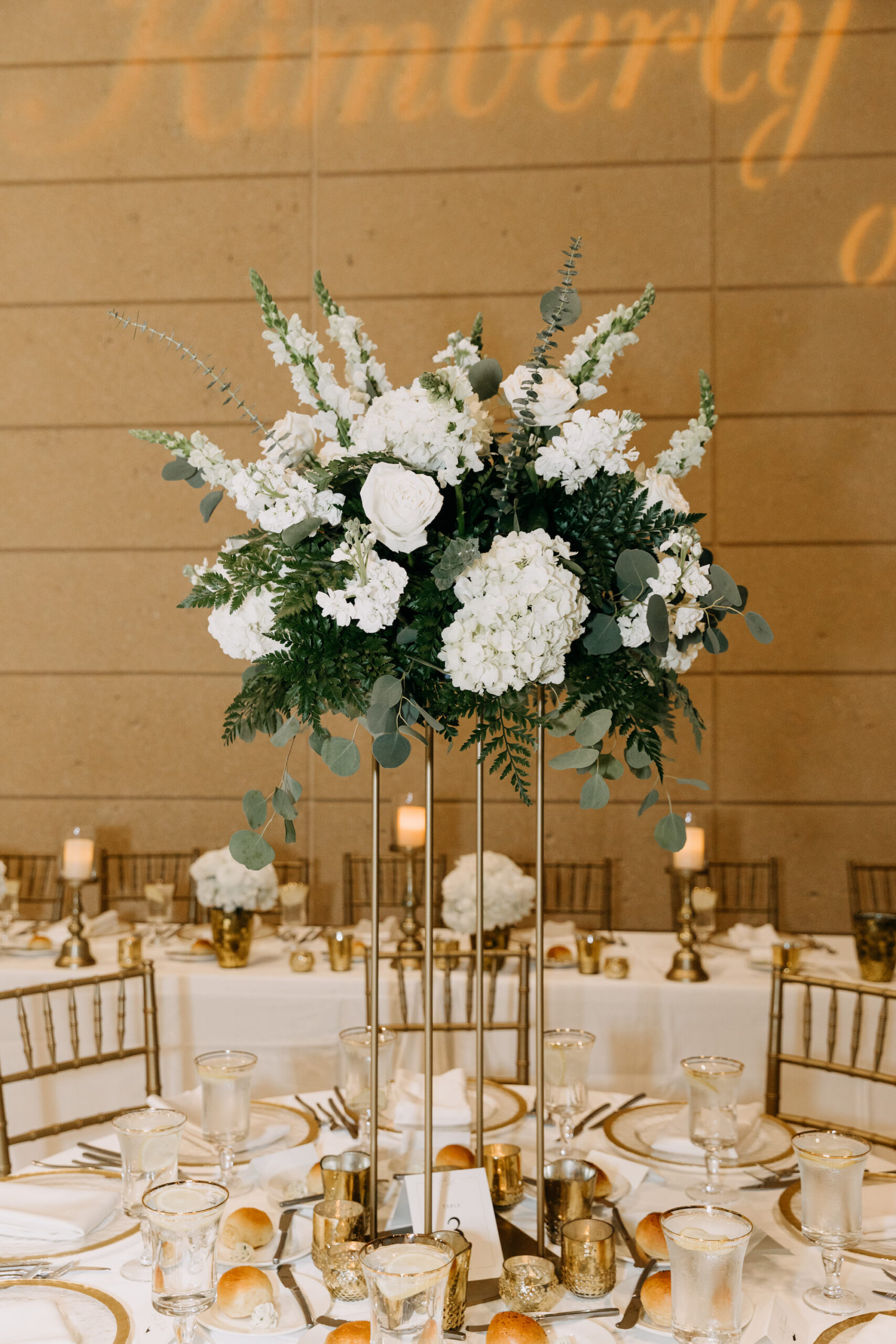 Tall Gold Column Vase with White Roses, White Veronica, and White Hydrangea Floral Centerpieces with Greenery | Classic Wedding Reception Inspiration