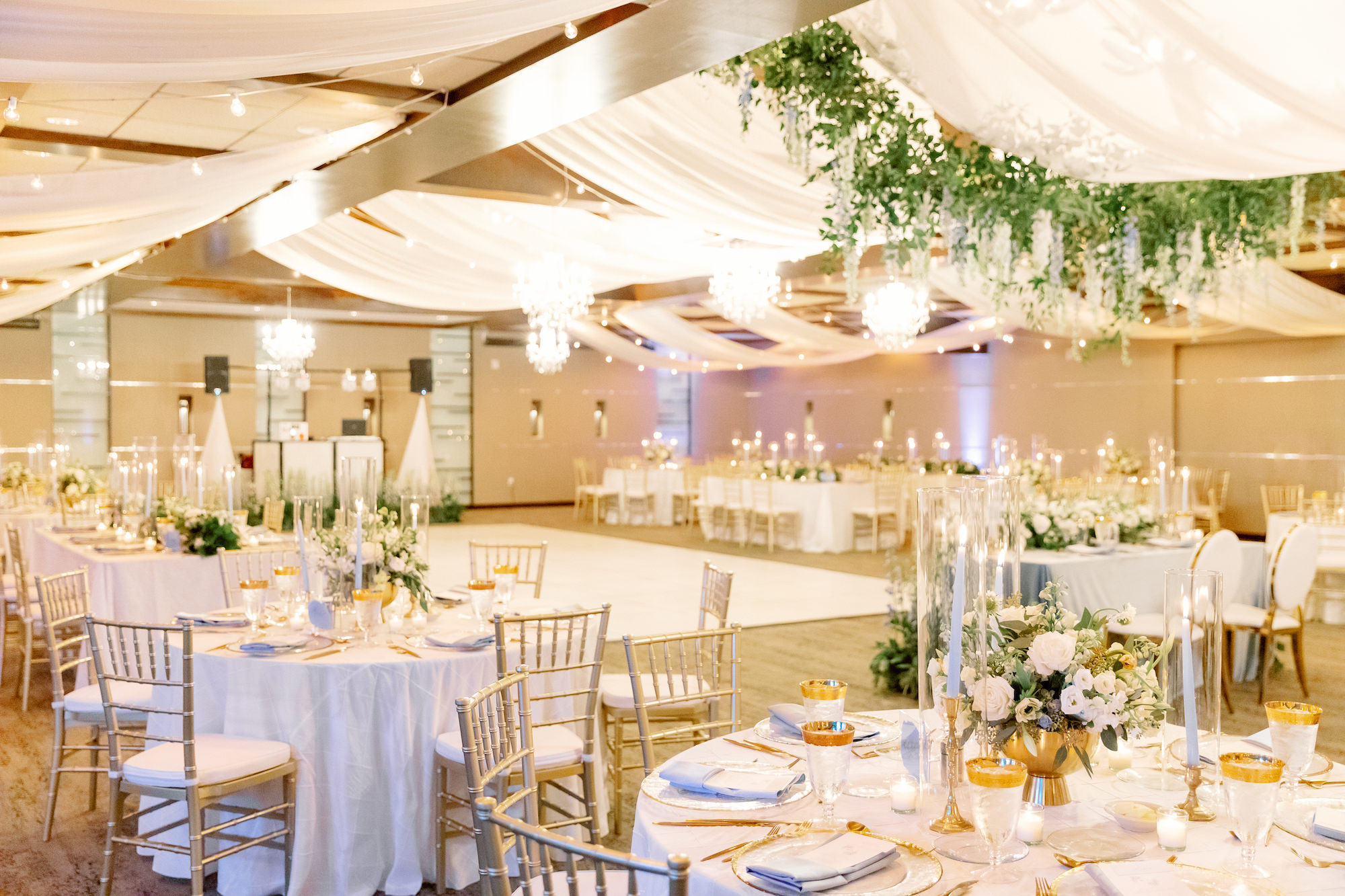 Elegant Reception Decor Ideas | Romantic Indoor White and Gold Spring Wedding Reception with Gold Chiavari Chairs and White Ceiling Drapery with Hanging Floral Arrangements | Sarasota Wedding Planner MDP Events | Florist Botanica International Design Studio | Venue Marie Selby Gardens
