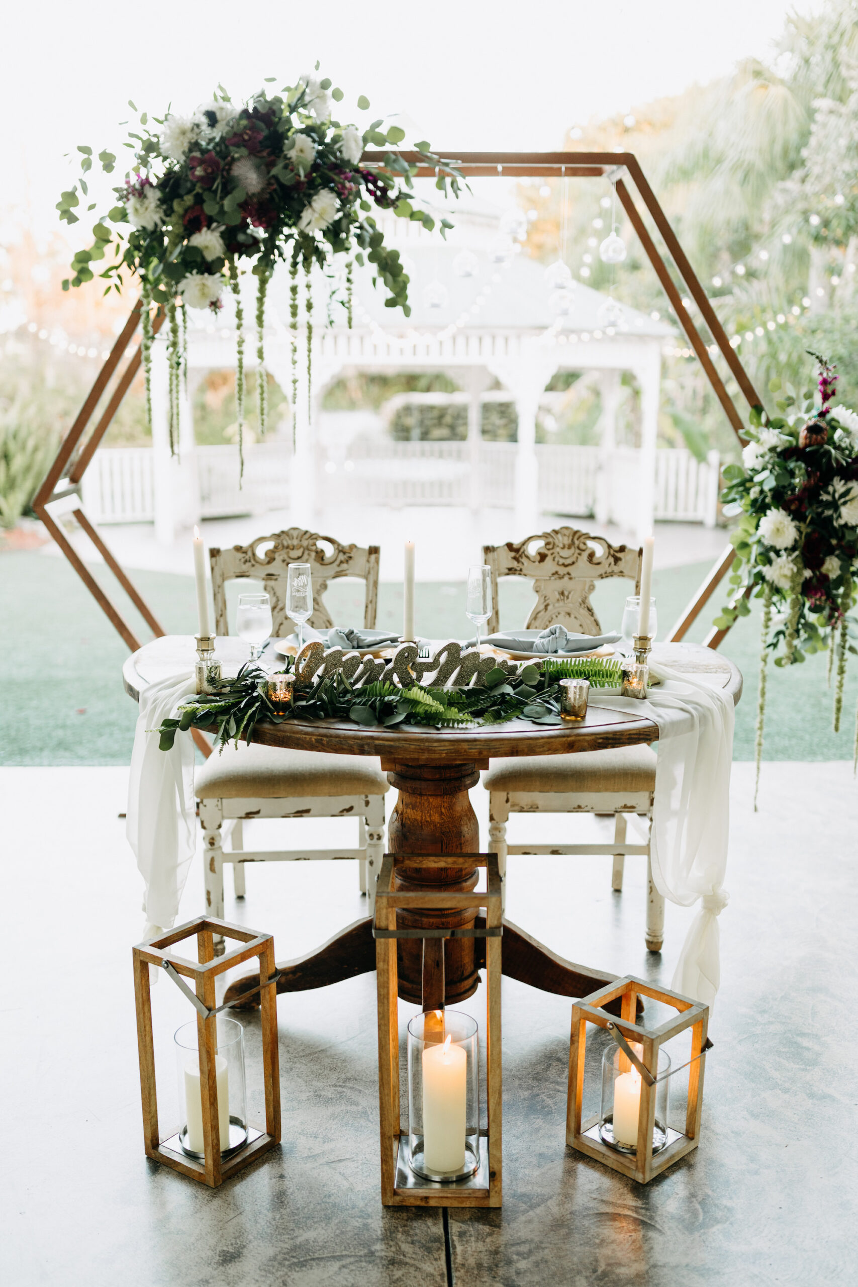 Geometric Hexagon Arch Wedding Sweetheart Head Table Backdrop with Candlelit Wooden Lanterns | Tropical Boho Reception Decor Ideas | Sarasota Wedding Florist Beneva Weddings