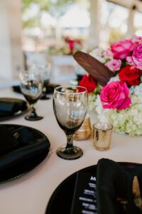 Modern Tropical Wedding Reception Decor Ideas | Black Chargers, Napkins, and Glassware with Pink Fuchsia Rose and Hydrangea Centerpieces and Champagne Linens | Tampa Bay Rentals Gabro Event Services